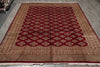 Load image into Gallery viewer, A rectangular area rug with a traditional Persian-style pattern, featuring a deep red central field with geometric medallions and a beige outer border, laid out on a gray floor.