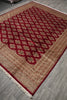 Load image into Gallery viewer, A rectangular area rug with a traditional Persian-style design, featuring a deep red lattice pattern over a beige and brown background, laid out on a gray wood floor.