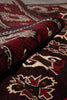 Load image into Gallery viewer, A close-up of a patterned rug or textile with a deep burgundy base and cream and red floral motifs.