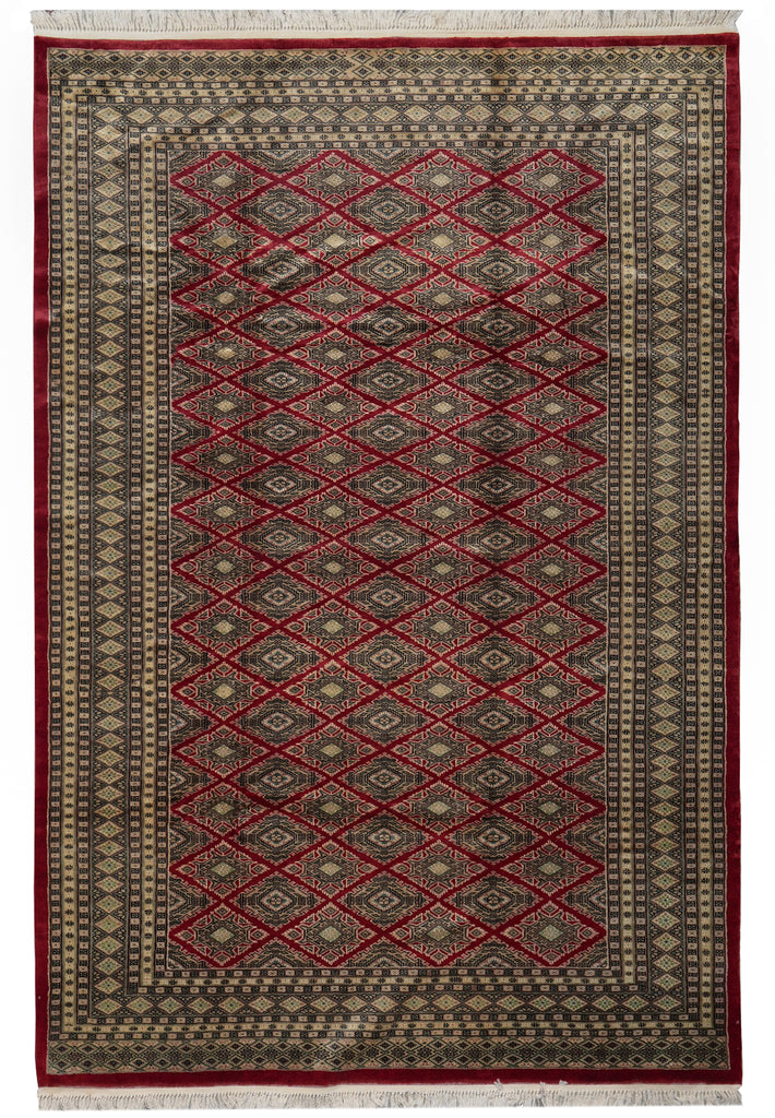 A traditional rectangular area rug with a geometric diamond pattern in red, beige, and dark brown, finished with white fringe on the top and bottom.