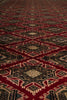 Load image into Gallery viewer, A close-up of a woven rug or textile with a repeating geometric diamond pattern in deep red, black, beige, and brown tones.