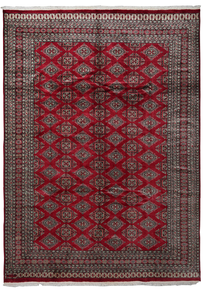 A traditional oriental area rug with a deep red field, featuring a repeating diamond pattern in beige, brown, and black, surrounded by a multi-layered geometric border.