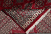 Load image into Gallery viewer, A close-up of a traditional patterned rug with deep red, beige, black, and gray geometric motifs and white fringe.