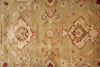 Load image into Gallery viewer, A close-up of a vintage-style area rug with a faded beige and tan background, featuring traditional geometric medallions and floral motifs in muted rust red and brown.