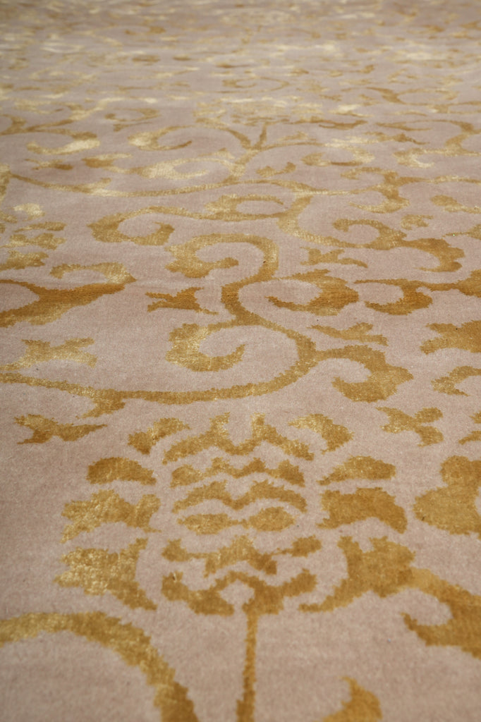 Close-up of a beige or cream textured surface with an ornate metallic gold damask pattern.