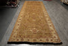 Load image into Gallery viewer, A long rectangular area rug with a traditional medallion pattern in beige, brown, and muted red, laid out on a gray wood-look floor.