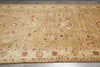 Load image into Gallery viewer, A rectangular area rug with a traditional oriental design, featuring a warm beige background with red and cream patterns, laid out on a gray tiled floor.
