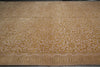 Load image into Gallery viewer, A large rectangular area rug with an intricate golden-brown floral and scroll pattern on a warm beige background, featuring a Greek key border along the bottom edge.