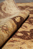 Load image into Gallery viewer, Close-up of a rolled area rug showing a detailed traditional pattern in shades of beige, brown, and tan.