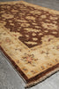 Load image into Gallery viewer, A close-up of a traditional patterned area rug with a beige and brown floral design, shown on a gray tiled floor.