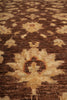 Load image into Gallery viewer, A close-up of a traditional patterned rug with a dark brown background and cream-colored geometric and floral motifs.