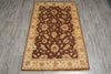 Load image into Gallery viewer, A rectangular area rug with an ornate traditional floral pattern, featuring a dark brown center and beige borders, laid out on a gray wood-look floor.