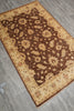 Load image into Gallery viewer, A rectangular area rug with an ornate floral pattern, shown from an overhead angle on a gray wood-look floor. The rug features a dark brown center field with beige floral motifs, surrounded by a wide beige border with smaller floral details.