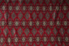 Load image into Gallery viewer, A close-up of a red patterned fabric with repeating diamond and cross motifs in beige, green, and black.