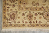 Load image into Gallery viewer, A close-up of a traditional patterned area rug with cream, beige, and muted brown floral motifs and fringe along the bottom edge.