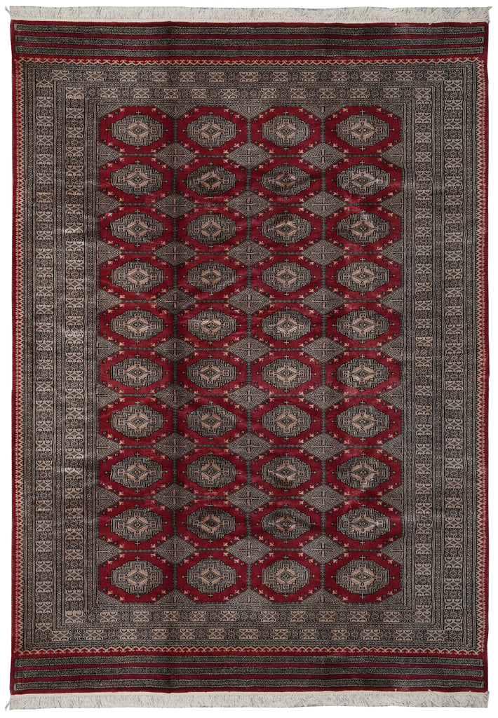 A rectangular area rug with a traditional Persian design, featuring a dark gray and red field with repeating geometric medallion motifs and a patterned border.