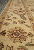 Load image into Gallery viewer, A close-up view of a traditional patterned area rug with a warm beige base, featuring floral motifs and ornate medallions in muted brown, olive green, and cream tones.