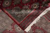 Load image into Gallery viewer, A close-up of a patterned rug with deep red, black, beige, and white geometric motifs and white fringe.
