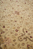 Load image into Gallery viewer, A close-up of a traditional patterned rug with a beige base and floral motifs in muted brown, gray, and burgundy.