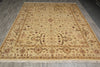 Load image into Gallery viewer, A rectangular area rug with an intricate traditional floral pattern, displayed on a gray wood-plank floor. The rug features a warm beige base with brown, gold, and muted pink accents in its detailed medallion and border motifs.