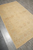 Load image into Gallery viewer, A rectangular area rug with a traditional floral pattern in shades of beige and light brown, shown laid out on a gray wood-look floor.