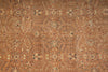 Load image into Gallery viewer, A close-up of a traditional patterned rug in warm tan and brown tones with repeating floral and geometric motifs in beige, muted blue, and small red accents.