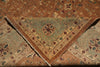 Load image into Gallery viewer, A close-up of a folded vintage area rug showing two patterned sections: a central triangular section in muted sage green with a floral medallion and fringe, surrounded by a warm brown and beige patterned border.