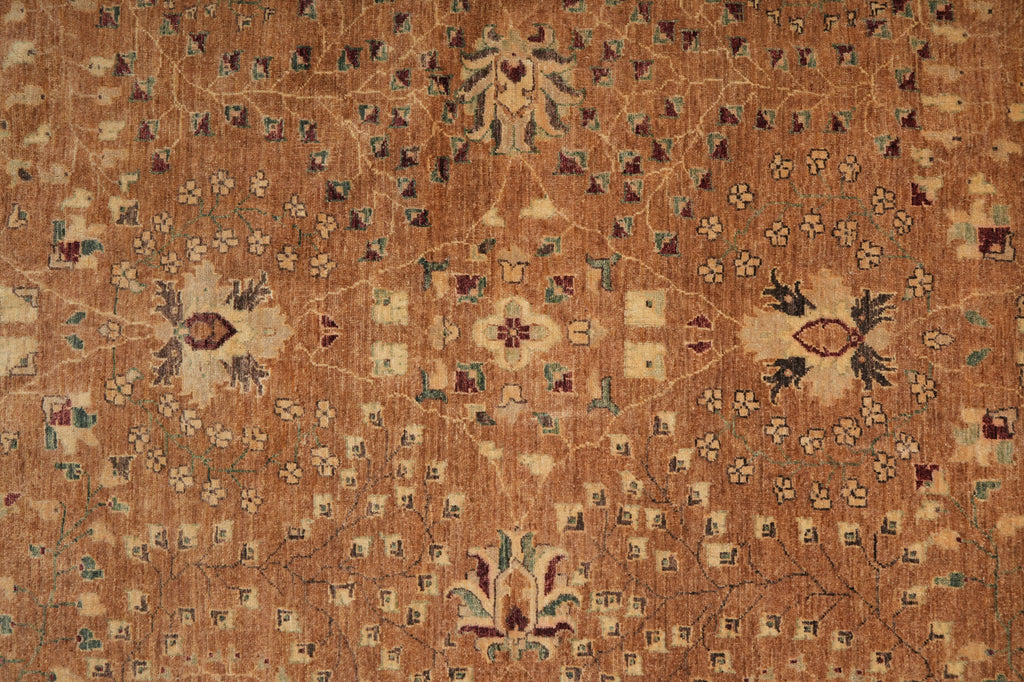 A close-up of an antique-style oriental rug with a warm brown and beige base, featuring intricate floral motifs and small geometric accents in muted blue, green, and burgundy.
