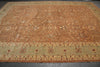 Load image into Gallery viewer, A large rectangular area rug with an intricate traditional pattern, featuring a warm tan and brown field with a contrasting light green and beige border.