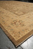 Load image into Gallery viewer, A traditional oriental area rug with a beige and brown base, featuring faded floral and geometric motifs in muted blue, green, and rust red, shown on a concrete floor.