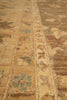 Load image into Gallery viewer, Close-up of a vintage patterned rug with a warm tan and brown base, featuring faded blue, green, and red floral motifs.