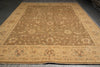 Load image into Gallery viewer, A large traditional area rug with an intricate floral and medallion pattern, shown laid out on a dark gray floor. The rug features a warm tan and beige base with muted brown, sage green, and light blue accents.