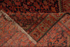 Load image into Gallery viewer, A close-up of a patterned rug with a folded corner showing its beige and rust-red woven design, dark border, and cream fringe.