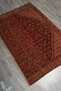 Load image into Gallery viewer, A traditional oriental area rug with an intricate floral pattern in deep red, brown, and black, laid out diagonally on a gray tiled floor.