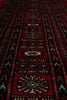 Load image into Gallery viewer, A close-up view of a traditional patterned rug with deep red fields, black geometric borders, and cream and beige central medallions.