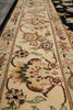 Load image into Gallery viewer, A close-up view of a traditional patterned area rug runner with floral motifs in beige, brown, pink, and green on a cream background.