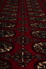 Load image into Gallery viewer, A close-up of a red patterned rug with repeating geometric and floral motifs in beige, black, and brown.