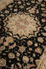 Load image into Gallery viewer, A close-up of an ornate traditional rug with a black field, beige central medallion, and floral motifs in beige, pink, and muted green.