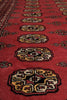 Load image into Gallery viewer, A close-up view of a red patterned rug with ornate medallion motifs in cream, black, and gold tones.