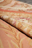 Load image into Gallery viewer, A close-up of a woven textile with a floral and scroll pattern in warm peach, beige, cream, and muted pink tones.
