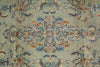 Load image into Gallery viewer, A close-up of an ornate floral patterned textile or rug with a muted sage green background and detailed motifs in blue, rust orange, cream, and dark navy.
