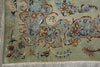 Load image into Gallery viewer, A close-up of an ornate floral rug with a sage green background, featuring intricate vine and flower patterns in blue, rust red, and gold, finished with white fringe.