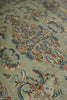 Load image into Gallery viewer, A close-up view of an ornate area rug with a light sage green background and intricate floral patterns in blue, rust orange, and cream.