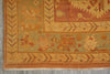 Load image into Gallery viewer, Close-up of an antique-style patterned rug corner showing a warm orange and beige floral design on a muted sage green field.