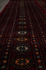 Load image into Gallery viewer, A close-up view of a dark red patterned rug with geometric and floral motifs in black, beige, and orange.