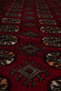 Load image into Gallery viewer, A close-up view of a red patterned rug with traditional geometric medallions and diamond motifs in black, gray, and beige.