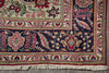 Load image into Gallery viewer, A close-up of an ornate patterned rug corner showing cream fringe, a dark navy field with floral motifs, and borders in pink, red, green, and beige.