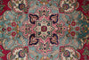 Load image into Gallery viewer, A close-up of a traditional patterned rug featuring a central floral medallion in pink, teal, cream, and burgundy with ornate vine motifs around it.