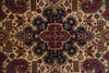 Load image into Gallery viewer, A close-up of a traditional geometric patterned rug with a central medallion. The design features a warm beige background with prominent navy blue, burgundy red, and muted green motifs.