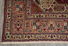 Load image into Gallery viewer, A close-up of a traditional patterned rug corner, showing a dusty pink field with red, navy, green, and beige geometric and floral motifs, finished with cream fringe.